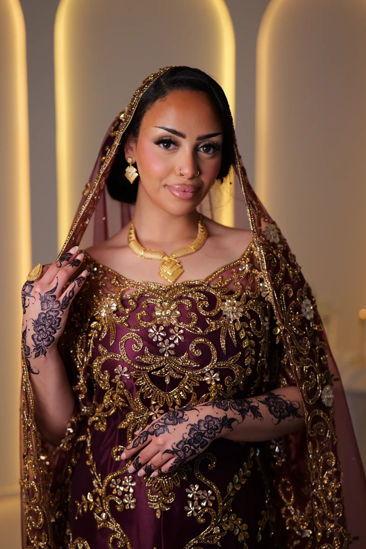 Portrait of the wine bridal look with gold embroidery around the neckline